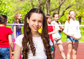 Portrait of girl with teens playing volleyball