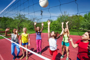 Volleyball game with playing teenage children