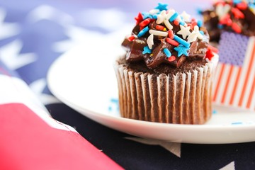 4th of July cupcakes with American flag background, shallow depth of field
