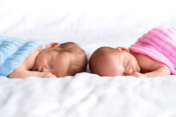 Boy and girl twins lying down in bed - obrazy, fototapety, plakaty
