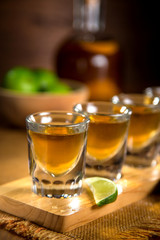 Close up of gold Tequila shots flight with cut limes and salt 