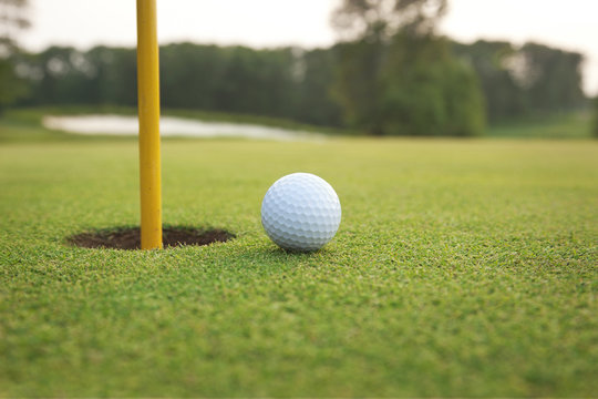 Close Up Of Golf Ball On A Green Near Hole With Pin