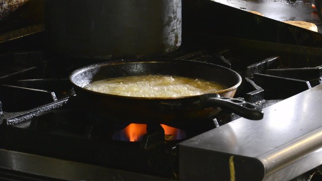 Chef deep frying shrimp in a commercial kitchen
