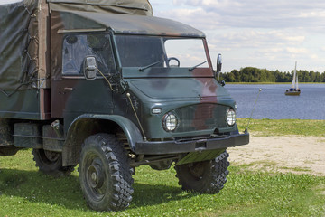 Old military truck near a water body