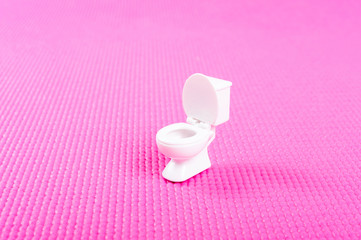 ピンクの背景と洋式トイレ便器
