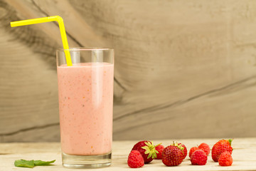 fresh berry smoothie with raspberries and strawberries on wooden background