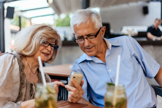 Mature Couple In Cafe Using Technology
