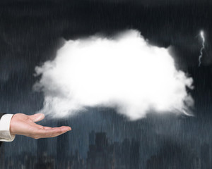 Male hand showing white cloud with heavy rain dark cityscape