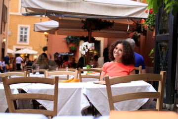Girl in dress sitting at a table in a cafe