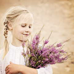 Young Girl Outdoors. Happy Girl with Heather Flowers in Great Br
