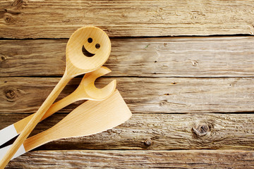 Wooden kitchen utensils on aged textured wood