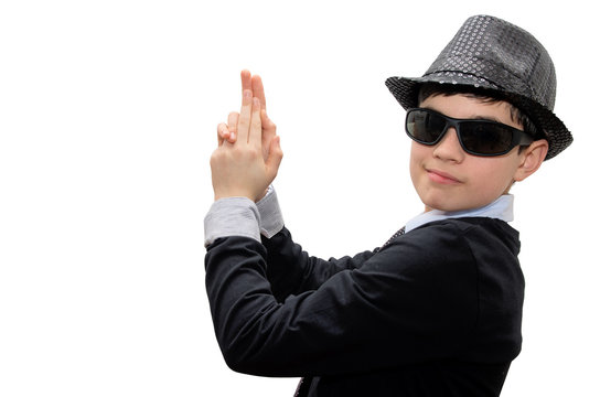 Boy with carnival costume.Man in black. Teenager in a carnival costume, wearing hat and sunglasses. Pretending to have an imaginary gun in his hands. Image isolated on white.