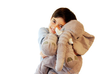 Kid with stuffed toy. Boy hugging a stuffed teddy elephant toy. Isolated on white.