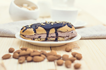 Fototapeta na wymiar Chocolate cake (eclair) with cup of coffee. profiteroles with chocolate cream