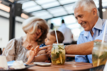 Fototapeta na wymiar Grandparents With Their Grandson At Cafe
