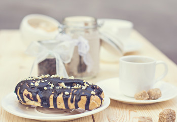 Chocolate cake (eclair) with cup of coffee.  profiteroles with chocolate cream