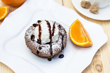 Warm dessert chocolate cake Fondant served on plate with ice-cream ball, almond chips, mint, icing, citron, cacao
