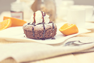 Warm dessert chocolate cake Fondant served on plate with ice-cream ball, almond chips, mint, icing, citron, cacao