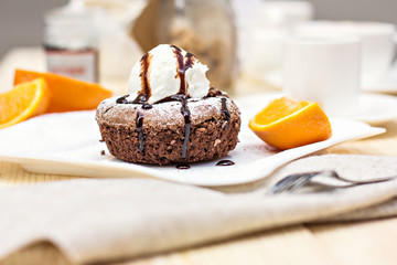 Warm dessert chocolate cake Fondant served on plate with ice-cream ball, almond chips, mint, icing, citron, cacao