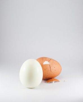 peeled boiled egg on white background.