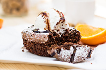 Warm dessert chocolate cake Fondant served on plate with ice-cream ball, almond chips, mint, icing, citron, cacao