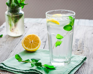 lemonade with ice, lemon slices and fresh mint in a glass