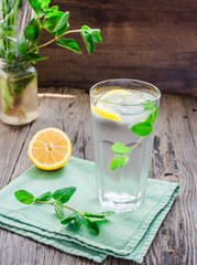 lemonade with ice, lemon slices and mint, rustic, selective focu