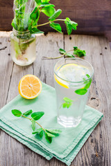 lemonade with ice, lemon slices and mint, rustic, selective focu