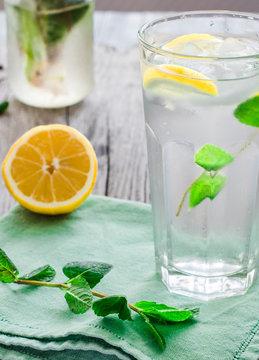 lemonade with ice, lemon slices and fresh mint in a glass