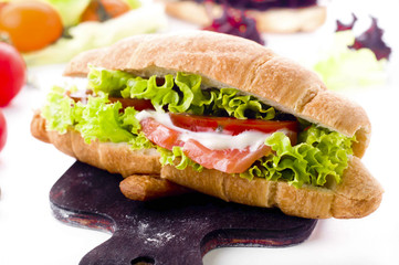 Croissant sandwich with salted salmon on plate,