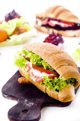 Croissant sandwich with salted salmon on plate,