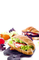 Croissant sandwich with salted salmon on plate,