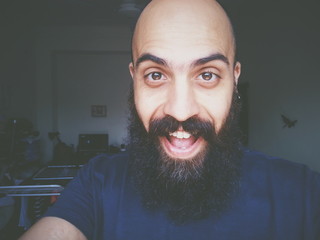 Happy bearded man smiling taking selfie