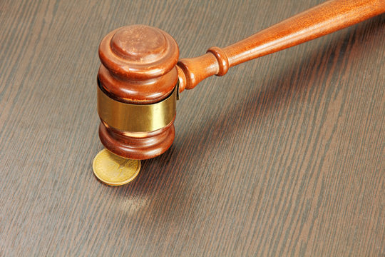 Auction hammer or judge gavel and one dollar coin taken closeup