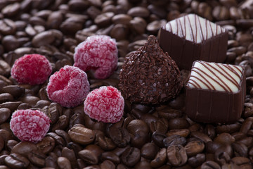 Chocolate with raspberries on coffee background, selective focus