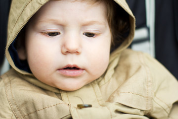 The cheerful child on a walk. Portrait of a baby in a jacket