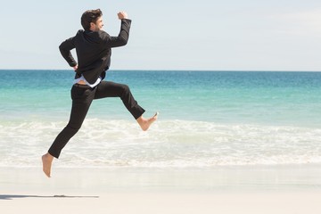 Fototapeta premium Businessman jumping in front of the sea 