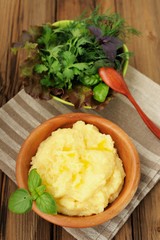 Polenta with green basil in wooden bowl with assorted salad bowl
