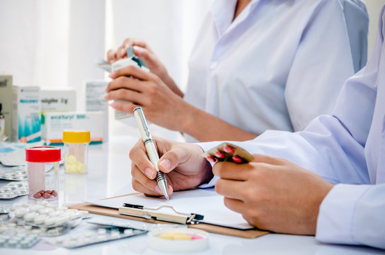 two pharmacists preparing prescription and medicine box