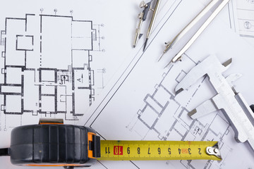 Architectural project, blueprints, blueprint rolls and divider compass, calipers, folding ruler on plans Engineering tools view from the top. Copy space. Construction background.