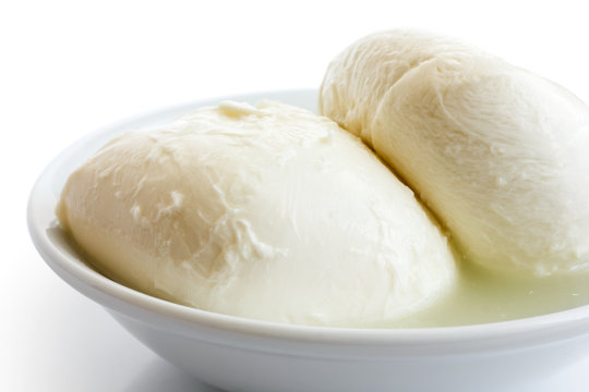 Two balls of mozzarella cheese in a dish, isolated on white.