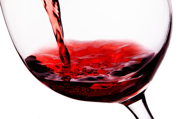 Red wine pouring in to the glass . closeup macro shot isolated on white with clipping path. 