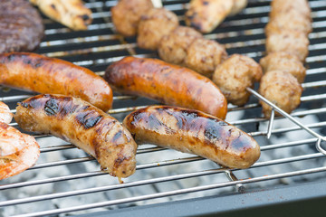 Mixed Grill BBQ - Burgers, kebabs, satay and sausages on a barbecue.
