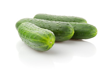 Four fresh Cucumbers on white