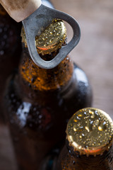 Brown ice cold beer bottles with old opener