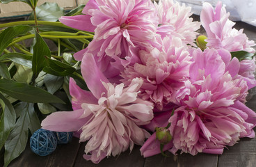large pink peony flowers lie on wooden boards