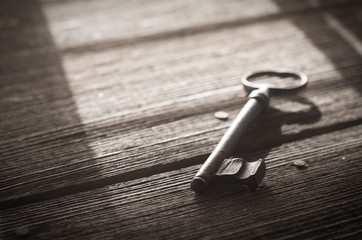 Rusty Old Skeleton Key on Dark Rustic Barnwood With Window Light