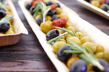 black and green olives, herbs, sun-dried tomatoes in an oblong d