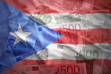 Obraz premium colorful waving puerto rican flag on a euro money background