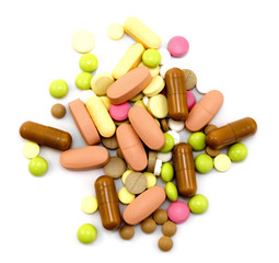 Hill of colorful pills for all ills isolated on white